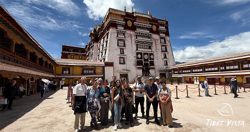 Tourists take a group photo in front of the Potala Palace