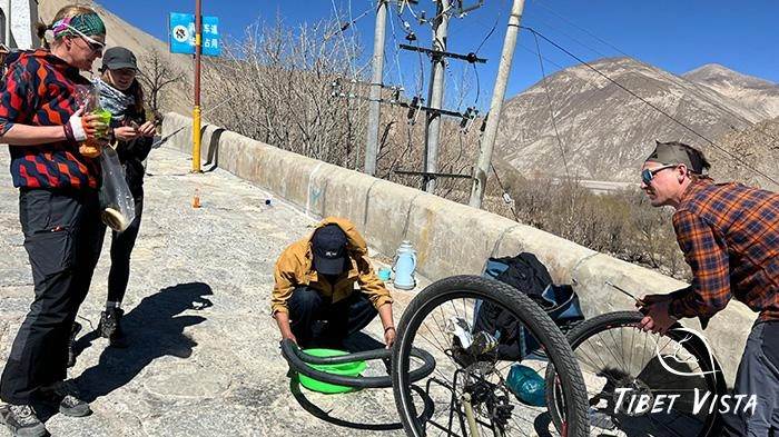 Our experienced Tibetan tour guide is fixing the tires for our guests.