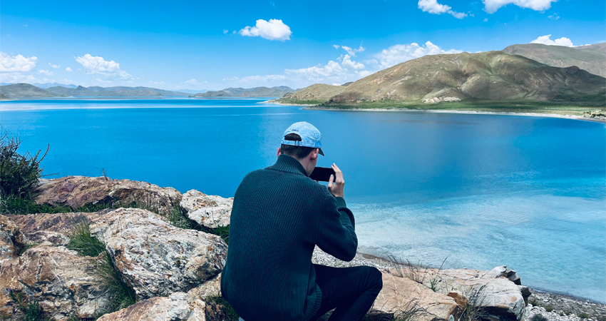 Traveler photographing Yamdrok Lake in Tibet