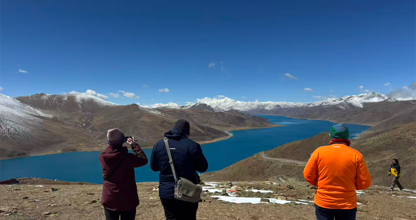Travelers viewing Yamdrok Lake panorama in Tibet