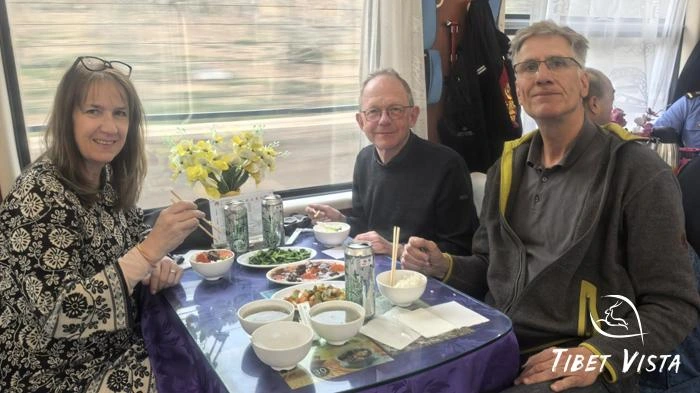 Our valued guests are savoring their dinner aboard the Tibet train